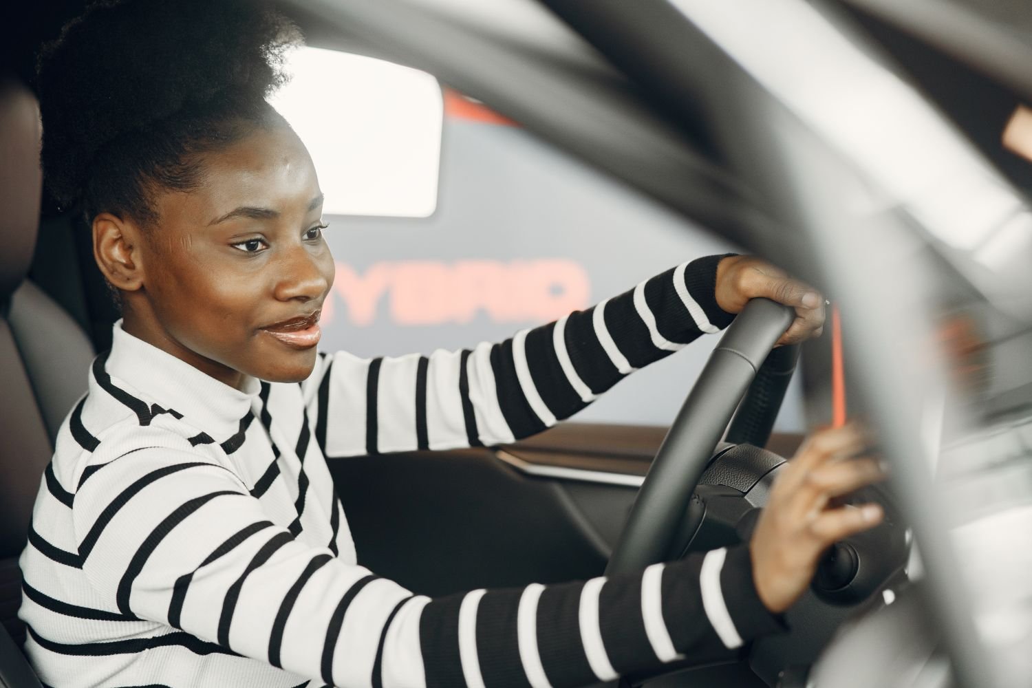 Une conductrice souriante au volant, prête à partager son trajet au Bénin